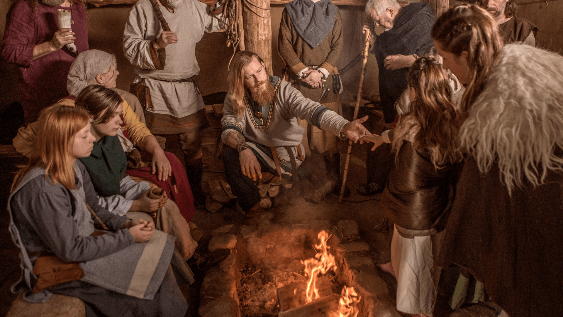 Group in Viking costume celebrating around fire